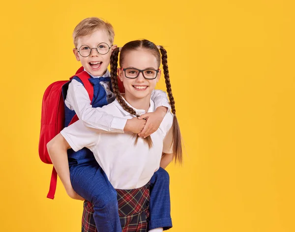 Menina Alegre Uniforme Escola Óculos Dando Passeio Piggyback Para Irmãozinho — Fotografia de Stock