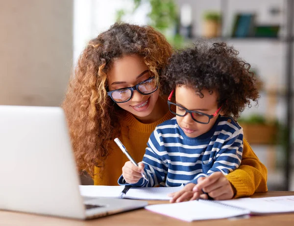 Niño Afroamericano Joven Escribiendo Algo Cuaderno Con Madre Mientras Trabaja — Foto de Stock