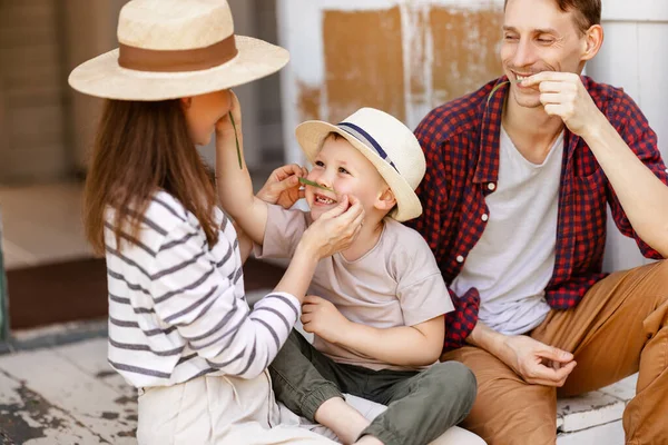 幸せな家族 母親の父と子供の息子がポーチに座って笑って夏にダチャカントリーハウスで遊んでいます — ストック写真