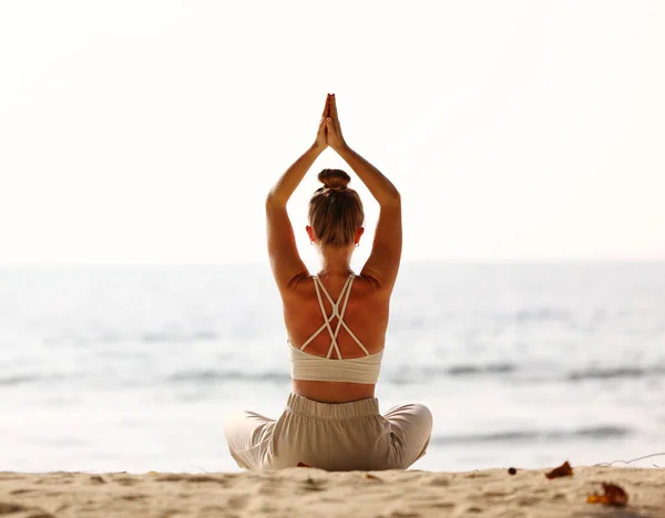 Visão Traseira Fêmea Sentada Padmasana Enquanto Meditava Sozinha Praia Contra — Fotografia de Stock