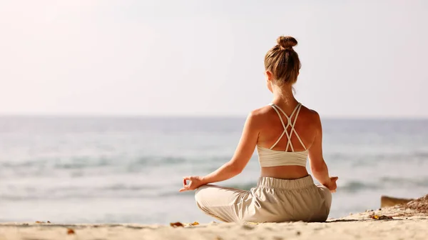 Visão Traseira Fêmea Sentada Padmasana Enquanto Meditava Sozinha Praia Contra — Fotografia de Stock