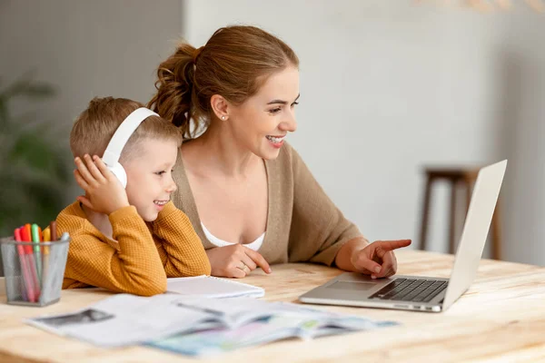 Vrolijke Kleine Schooljongen Koptelefoon Doet Oefeningen Het Copybook Terwijl Studeren — Stockfoto