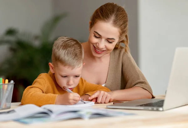 Веселий Маленький Школяр Навушниках Робить Вправи Копіювальній Книзі Вивчаючи Дистанційно — стокове фото