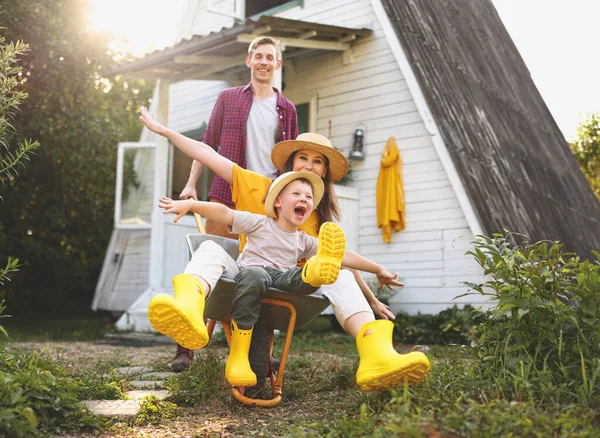 Happy Mother Son Outstretched Arms Smiling Riding Wheelbarrow Father Cottage — Stock Photo, Image