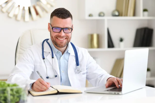 Wesoły Przyjazny Lekarz Białym Płaszczu Stetoskopem Ramionach Patrzący Uśmiechem Aparat — Zdjęcie stockowe