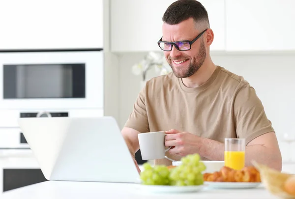 Jovem Sorrindo Bonito Homem Vestindo Óculos Trabalhando Remotamente Laptop Enquanto — Fotografia de Stock