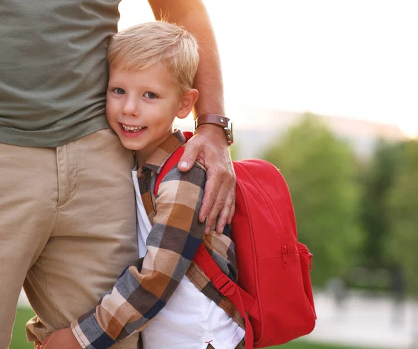 Lindo Colegial Feliz Con Mochila Roja Abrazando Pierna Abrazando Padre —  Fotos de Stock