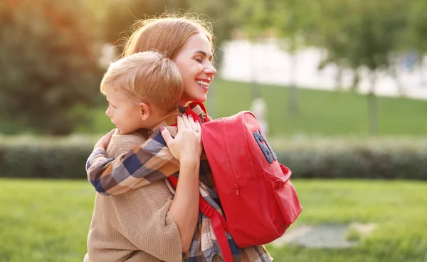 Giovane Madre Amorevole Abbracciare Piccolo Figlio Scolaro Con Zaino Rosso — Foto Stock
