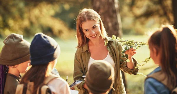 Group Curious School Children Notebooks Listening Young Female Teacher While — Stock Photo, Image