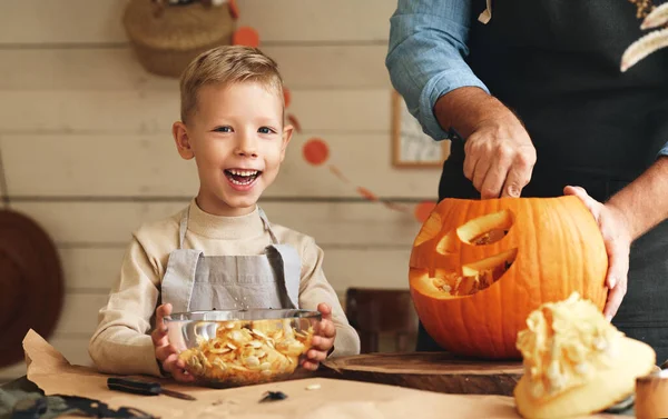 Cute Szczęśliwy Chłopiec Pomaga Ojcu Rzeźbić Dynię Halloween Stojąc Kuchni — Zdjęcie stockowe