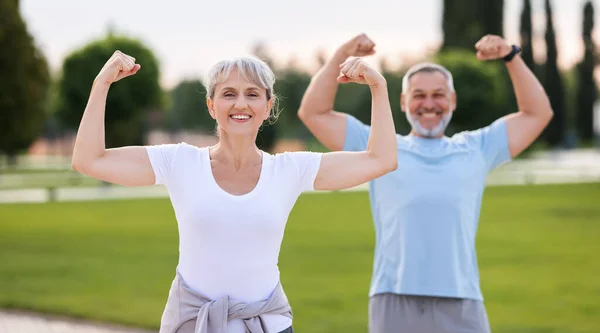 Fit Elderly Couple Working Out Both Flexing Arms Showing Biceps — Stock Photo, Image