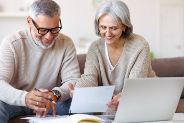 Smiling senior couple calculate expenses or planning budget together, reading notification letter with good news from bank , retired family husband and wife paying bills online on laptop clipart