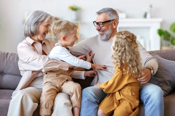 Játékos Gyerekek Nagymama Csiklandozó Nagypapa Miközben Jól Érzik Magukat Otthon — Stock Fotó