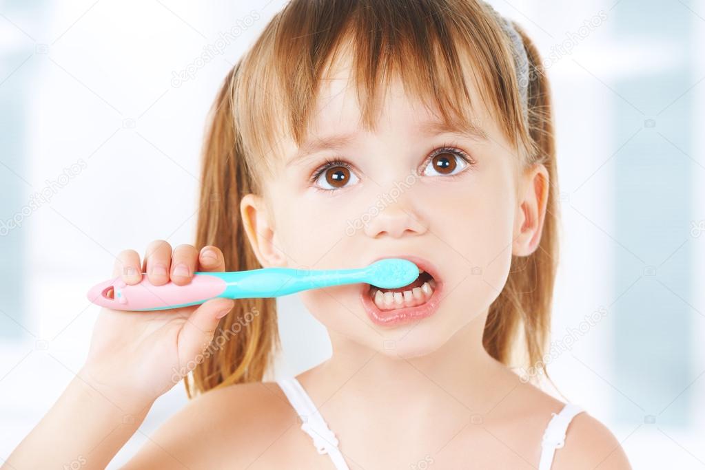 happy little girl brushing her teeth