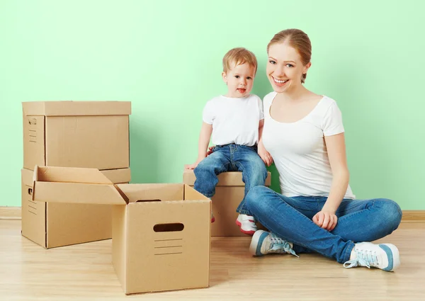 Mutlu aile anne ve bebek kız karton kutular ile boş bir dairede — Stok fotoğraf