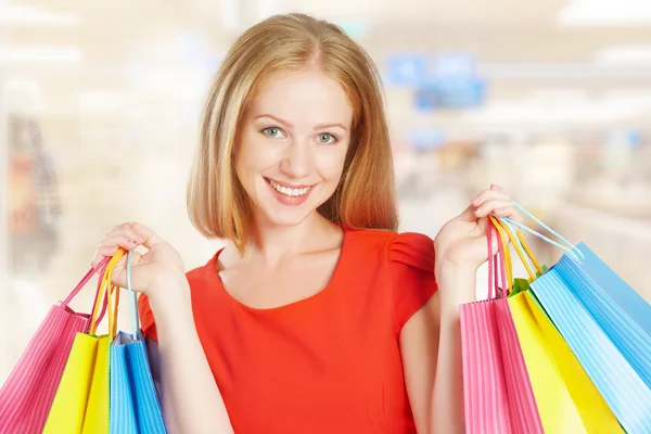 Šťastná žena s taškou na nákupy v obchodě — Stock fotografie