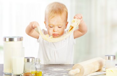 küçük bebek kız yemek pişiriyor, hamur kabartma kneads