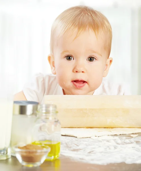 Pequena menina está cozinhando, amassa assar massa — Fotografia de Stock