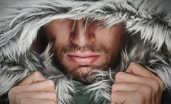 Rosto brutal de um homem com cerdas de barba e inverno encapuzado — Fotografia de Stock