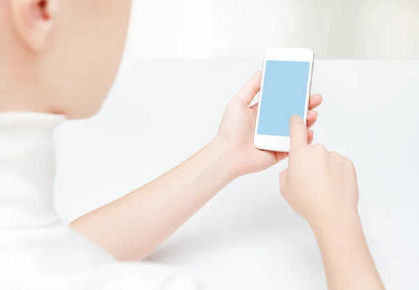 Telefone com uma tela vazia em branco nas mãos da mulher — Fotografia de Stock