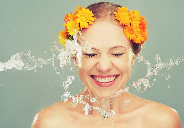 Beauty laughing girl with splashes of water and yellow flowers — Stock Photo, Image