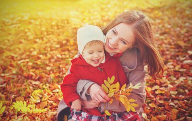 mutlu bir aile: anne ve çocuk küçük kızı oyun sonbaharda sarılma