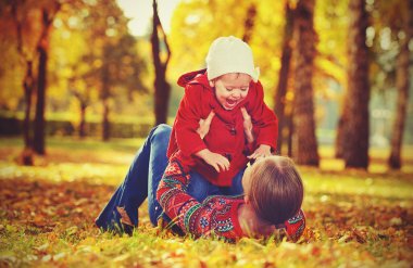 mutlu bir aile: anne ve çocuk oynamaya ve sonbaharda gülüyor küçük kızı