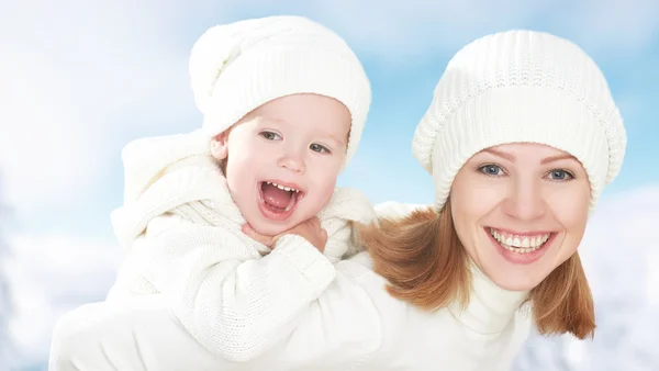 Família feliz em uma caminhada de inverno. Mãe e bebê filha nos chapéus brancos — Fotografia de Stock