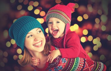 happy family mother and little daughter playing in the winter for Christmas clipart
