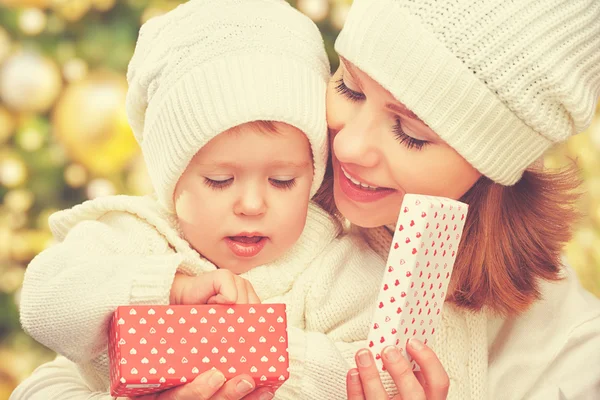 Família feliz mãe e filha em chapéus com presente de Natal no inverno — Fotografia de Stock