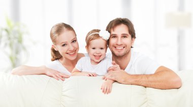 Mutlu aile anne, baba, çocuk bebek kızı evde oynarken ve gülerek Divan
