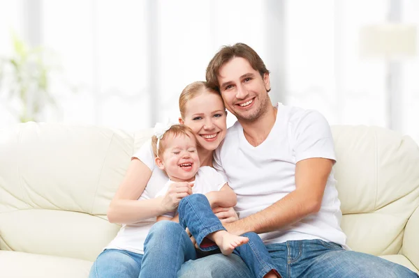 Mãe de família feliz, pai, filha bebê criança em casa no sofá brincando e rindo — Fotografia de Stock