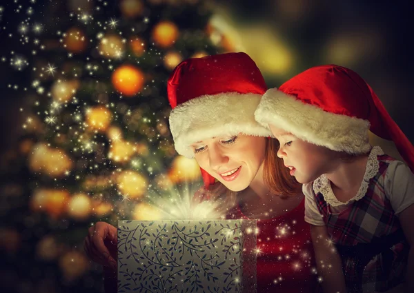 Christmas magic gift box and a happy family mother and daughter baby girl Stock Photo