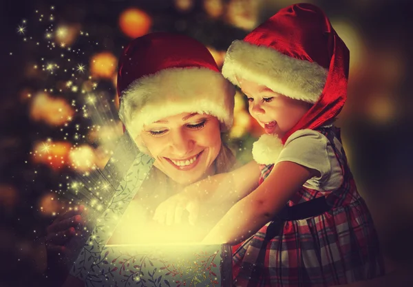 Caja de regalo mágica de Navidad y una familia feliz madre e hija niña — Foto de Stock