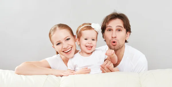 Feliz familia madre, padre, hija bebé en casa en el sofá jugando y riendo — Foto de Stock