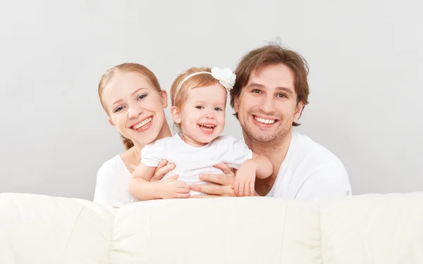 Feliz familia madre, padre, hija bebé en casa en el sofá jugando y riendo —  Fotos de Stock