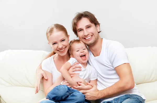 Happy family mother, father, child baby daughter at home on  sofa playing and laughing Royalty Free Stock Images
