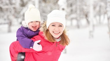 mutlu aile anne ve bebek kız kız oynama ve kış karda gülüyor
