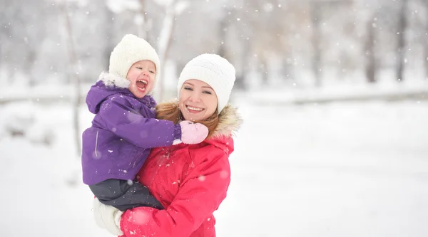 Gelukkig familie moeder en baby meisje dochter spelen en lachen in wintersneeuw — Stockfoto