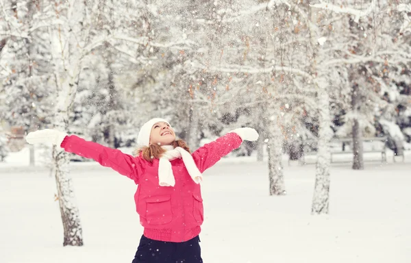 Chica feliz disfrutando de la vida y lanza nieve en invierno al aire libre —  Fotos de Stock