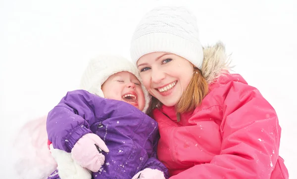 Happy family mother and baby girl daughter playing and laughing in winter snow — Stock Photo, Image