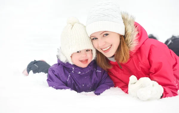 Família feliz mãe e bebê menina filha brincando e rindo no inverno neve — Fotografia de Stock