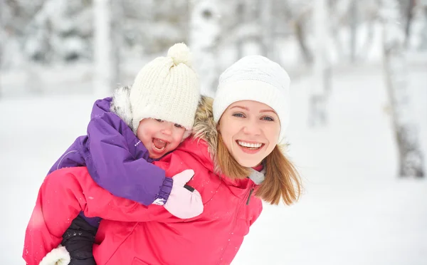 Happy family mother and baby girl daughter playing and laughing in winter snow — Stock Photo, Image