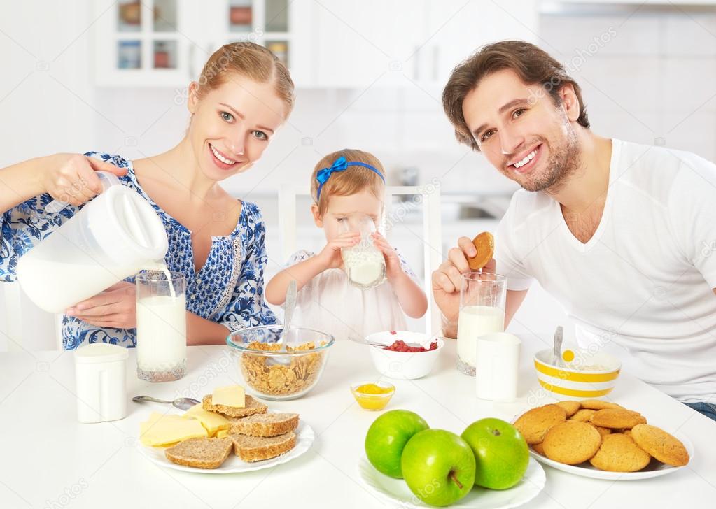 Happy family mother, father, child baby daughter having breakfast