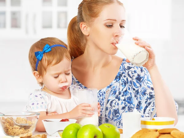 Feliz familia madre e hija niña en el desayuno: galletas con leche —  Fotos de Stock