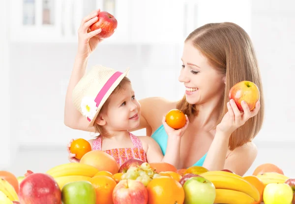 Família feliz mãe e filha menina, comer comida vegetariana saudável, frutas — Fotografia de Stock