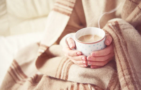 Xícara de café quente que aquece nas mãos de uma menina — Fotografia de Stock