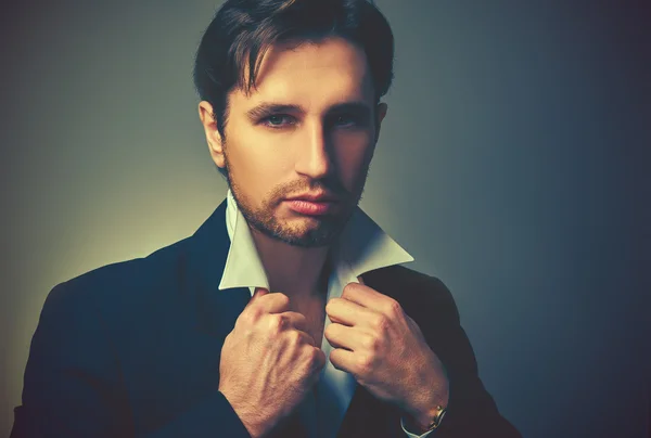 Stylish handsome man in a suit in dark — Stock Photo, Image