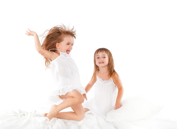 Mutlu bir aile. oynarken yatağa atlama ikiz kız çocukları bir — Stok fotoğraf