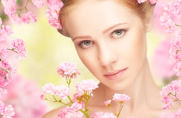 Bellezza viso di giovane bella donna con fiori rosa nel suo ha — Foto Stock